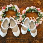Flower girls tiara and white shoes laid out on rustic timber table Charter Towers